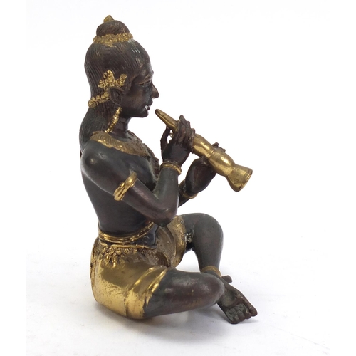 888 - Asian partially gilt bronze figure of a female playing a flute, 15cm high