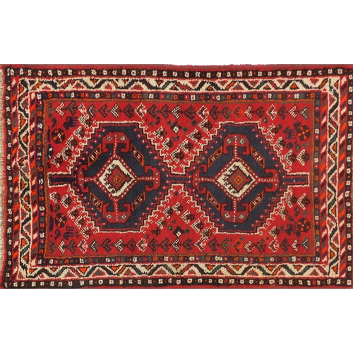 1598 - Rectangular Persian rug having an all over geometric floral design onto a red ground, 123cm x 80cm