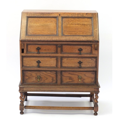 1603 - Oak bureau with a fall enclosing a fitted interior above three drawers, 101cm H x 76cm W x 38cm D