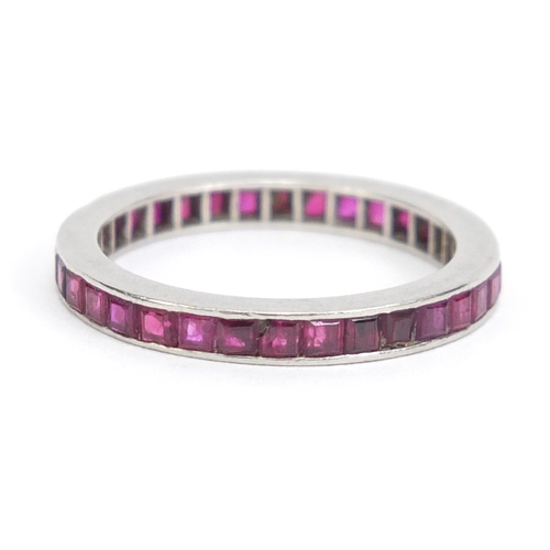 1101 - Unmarked white metal ruby eternity ring, size L, 2.6g