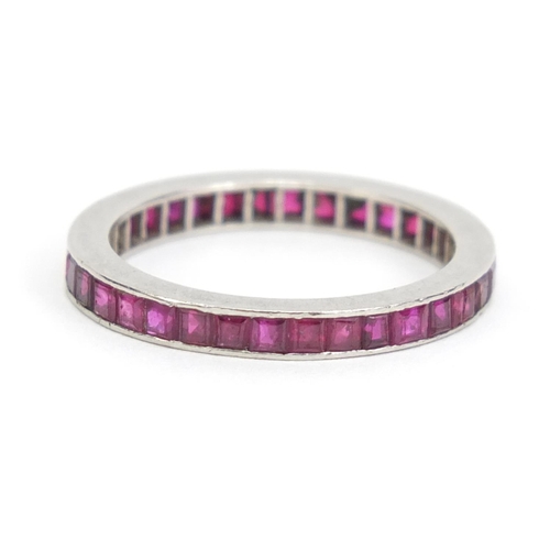 1101 - Unmarked white metal ruby eternity ring, size L, 2.6g