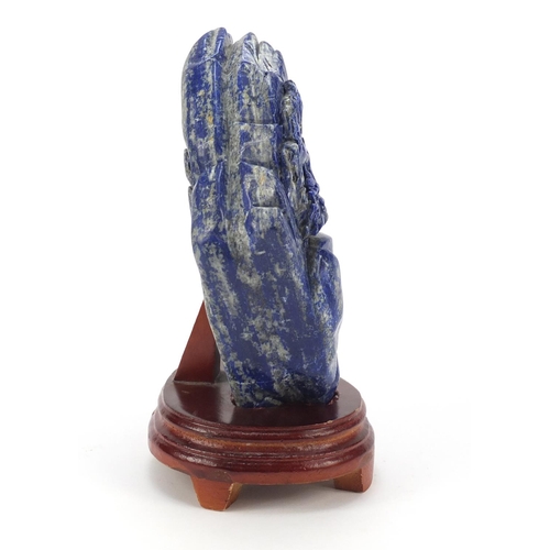 135 - Large Chinese lapis lazuli fragment carved with a figure amongst mountains beside a tree raised on a... 