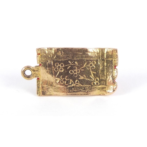 958 - 9ct gold and enamel Aladdin on a magic carpet charm, 1.8cm in length, 1.8g