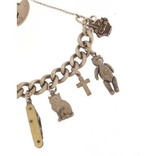 483 - Silver charm bracelet with a selection of mostly silver charms including elephant and articulated te... 