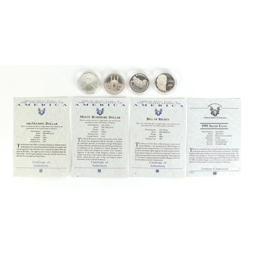 374 - Four American silver dollars with certificates of authenticity including 1995 silver eagle and 1984 ... 