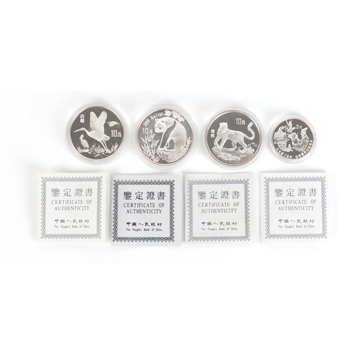 375 - Four Chinese silver coins with certificates of authenticity including three 10 yuans