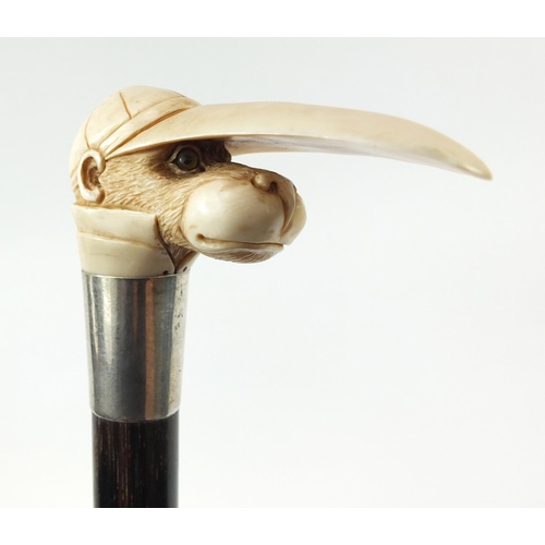 36 - Good ebonised walking stick with carved ivory pommel in the form of a monkey's head wearing a jockey... 