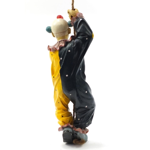 1452 - Novelty hand painted model of a clown climbing rope, 63cm high