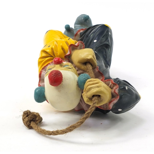 1452 - Novelty hand painted model of a clown climbing rope, 63cm high