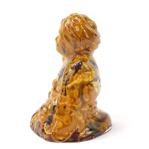 472 - Turkish Canakkale pottery figure of a man having a yellow and brown glaze, 15.5cm high