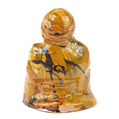 472 - Turkish Canakkale pottery figure of a man having a yellow and brown glaze, 15.5cm high