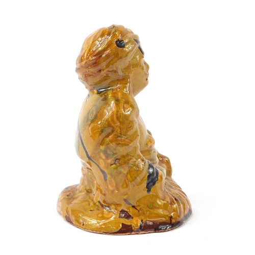 472 - Turkish Canakkale pottery figure of a man having a yellow and brown glaze, 15.5cm high