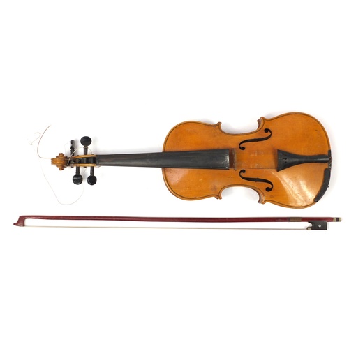 1043 - Old wooden violin with two bows having mother of pearl frogs and a fitted case, the violin back 14 i... 