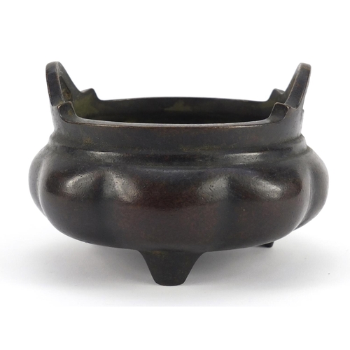 1086 - Chinese patinated bronze tripod incense burner with twin handles, character marks to the base, 10cm ... 