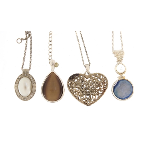 877 - Silver and white metal pendants on necklaces including one set with semi precious stones and a pierc... 