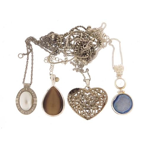 877 - Silver and white metal pendants on necklaces including one set with semi precious stones and a pierc... 