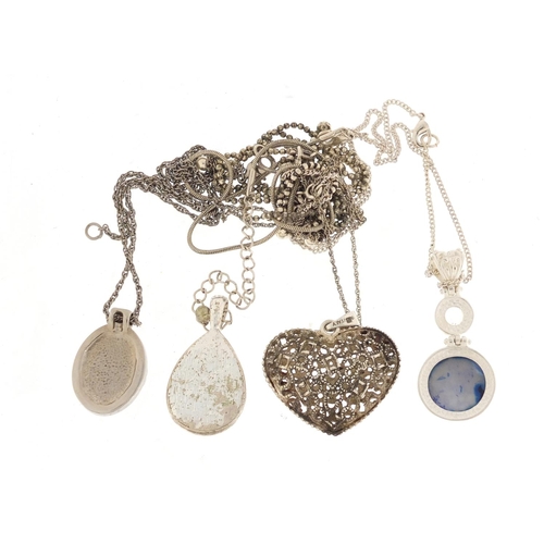 877 - Silver and white metal pendants on necklaces including one set with semi precious stones and a pierc... 