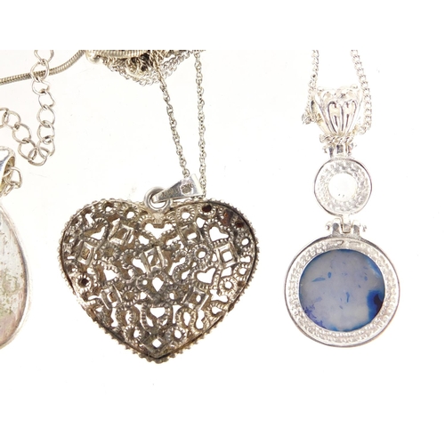 877 - Silver and white metal pendants on necklaces including one set with semi precious stones and a pierc... 