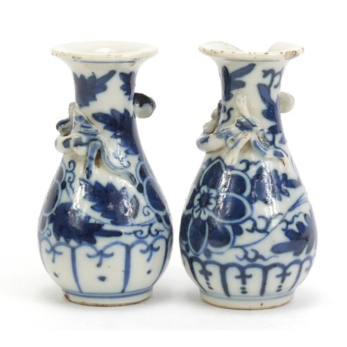 1139 - Pair of Chinese blue and white porcelain vases with relief dragons, each hand painted with flowers, ... 