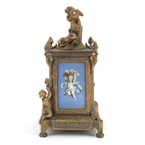 611 - Continental bronze mantel clock with porcelain panels mounted with cherubs. 30cm high