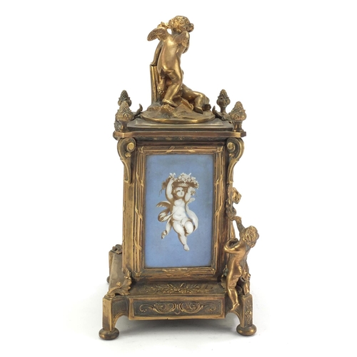 611 - Continental bronze mantel clock with porcelain panels mounted with cherubs. 30cm high