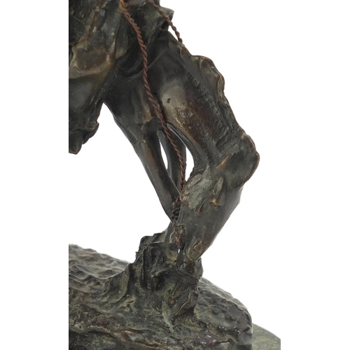 492 - Patinated bronze figure of a cowboy on horseback in the style of Frederick Remington, raised on an o... 