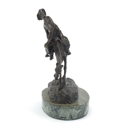 492 - Patinated bronze figure of a cowboy on horseback in the style of Frederick Remington, raised on an o... 