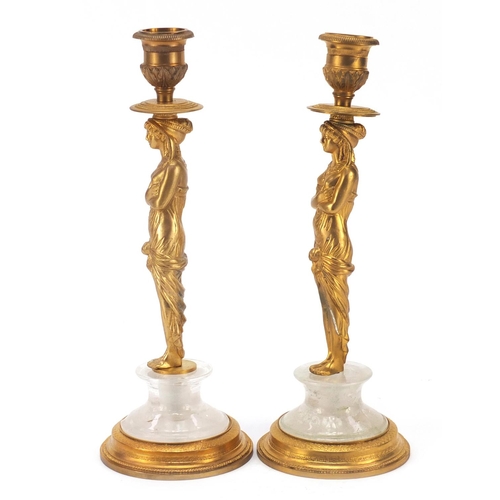 114 - Pair of French Empire style Egyptian revival gilt bronze and rock crystal candlesticks, each 25cm hi... 