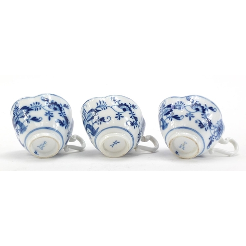 91 - Five Meissen demitasse cups and four saucers, each hand painted in the Blue Onion pattern, crossed s... 