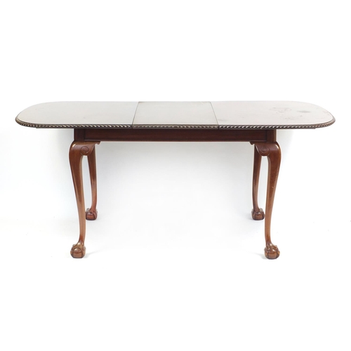 2184 - Mahogany extending dining table raised on ball and claw feet and extra leaf, together with a set of ... 