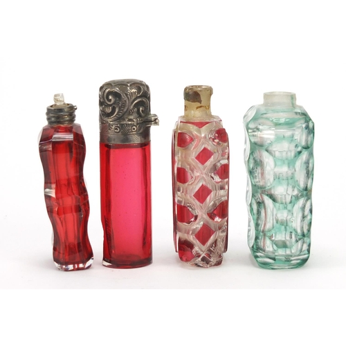 281 - Four Victorian glass scent bottles including a cranberry example with embossed silver lid, the large... 