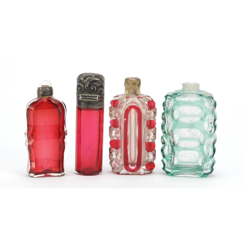 281 - Four Victorian glass scent bottles including a cranberry example with embossed silver lid, the large... 