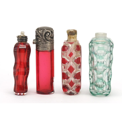 281 - Four Victorian glass scent bottles including a cranberry example with embossed silver lid, the large... 