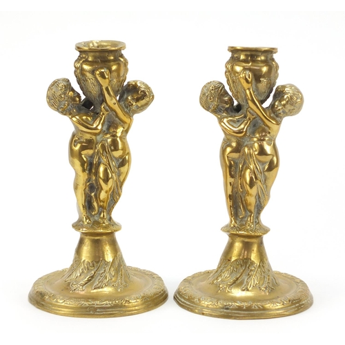 115 - Pair of classical bronzed candlesticks with Putti columns, each 24cm high