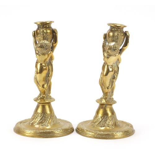 115 - Pair of classical bronzed candlesticks with Putti columns, each 24cm high