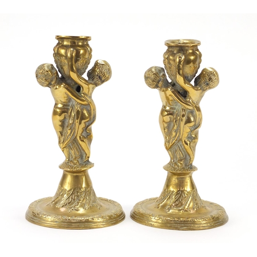 115 - Pair of classical bronzed candlesticks with Putti columns, each 24cm high