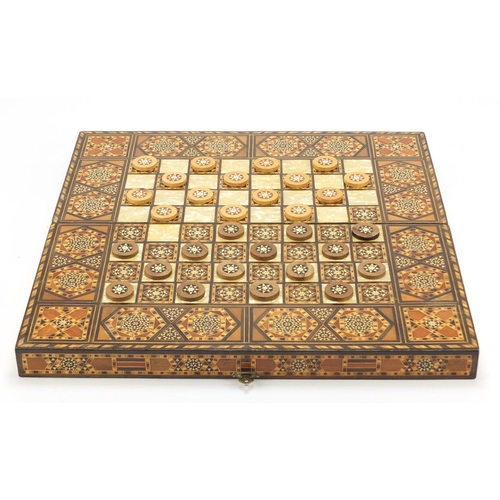 902 - Moorish style Syrian inlaid folding games board with draughts, 50cm x 50cm