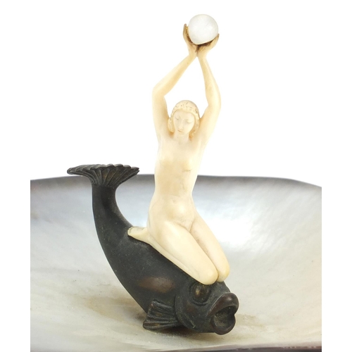 389 - Art Deco abalone centrepiece mounted with a nude carved ivory female, knelt on a bronzed fish, 18cm ... 