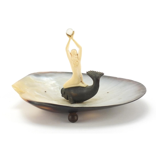 389 - Art Deco abalone centrepiece mounted with a nude carved ivory female, knelt on a bronzed fish, 18cm ... 