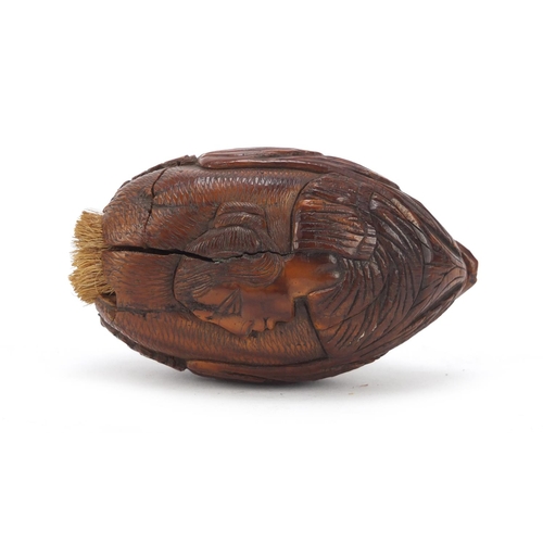 121 - 18th century coquilla nut snuff box carved with a male and female, 8.5cm in length
