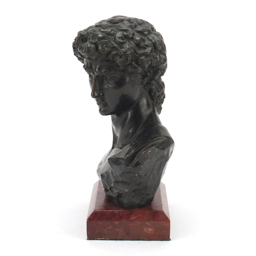 119 - Large patinated bronze bust of Michelangelo's David, raised on a rectangular rouge marble base, 30cm... 