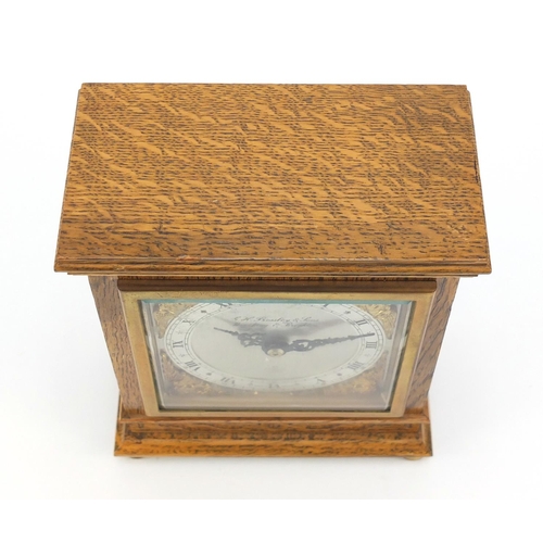 612 - Carved oak Elliott mantle clock with silvered face having gilt spandrels retailed by G H Pressley & ... 