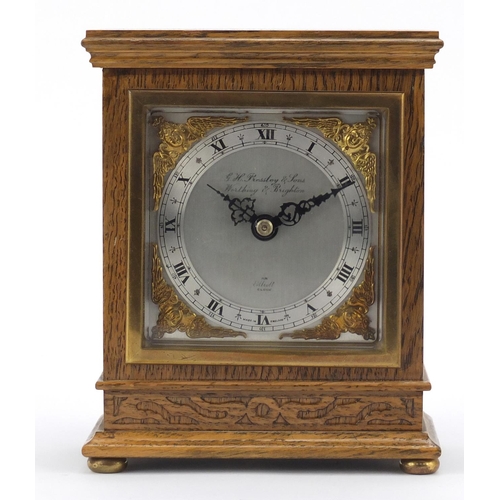 612 - Carved oak Elliott mantle clock with silvered face having gilt spandrels retailed by G H Pressley & ... 