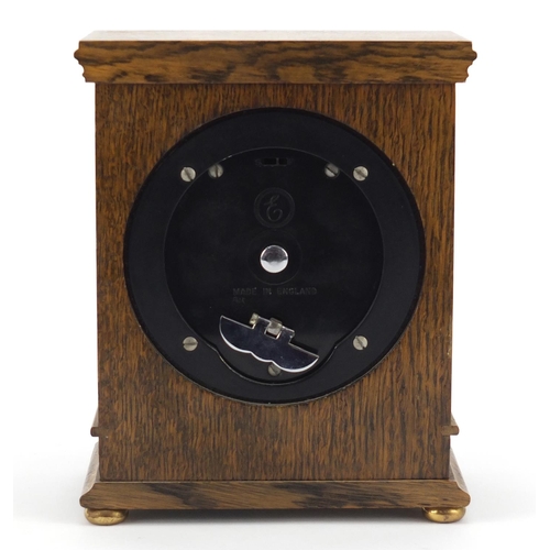 612 - Carved oak Elliott mantle clock with silvered face having gilt spandrels retailed by G H Pressley & ... 