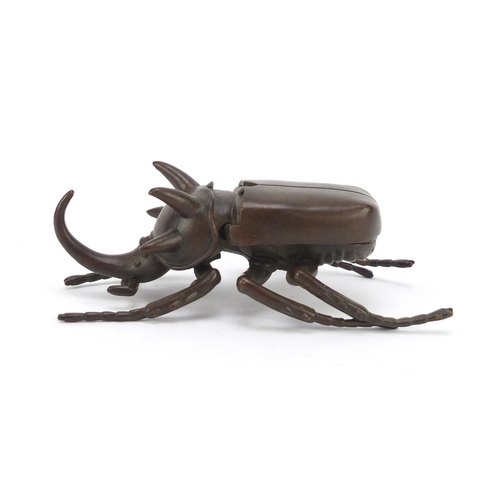 153 - Japanese patinated bronze rhinoceros beetle, impressed character marks to the underside, 10cm in len... 