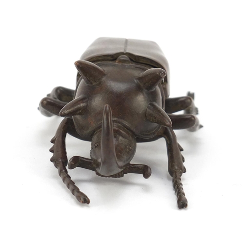 153 - Japanese patinated bronze rhinoceros beetle, impressed character marks to the underside, 10cm in len... 