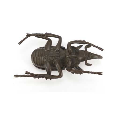 153 - Japanese patinated bronze rhinoceros beetle, impressed character marks to the underside, 10cm in len... 