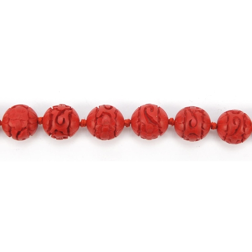 378 - Chinese carved cinnabar lacquer bead necklace with gold coloured metal clasp, 68cm in length