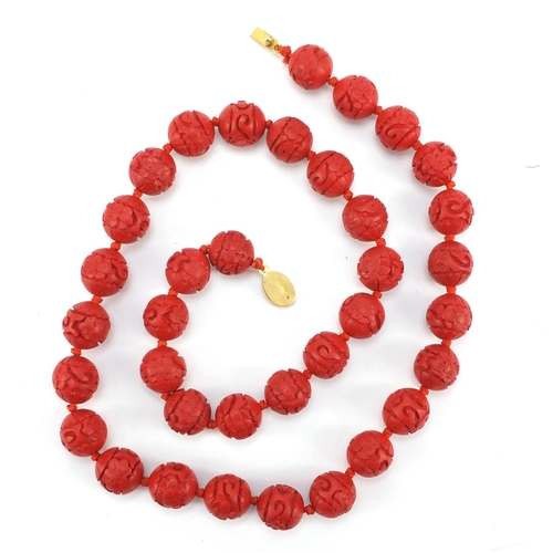 378 - Chinese carved cinnabar lacquer bead necklace with gold coloured metal clasp, 68cm in length