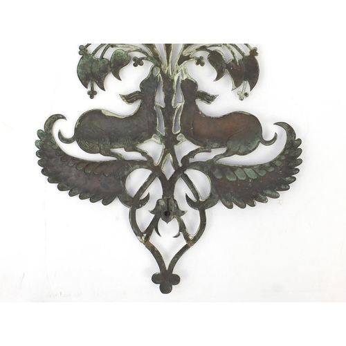 131 - Arts & Crafts copper wall sconce embossed with two beasts, 67cm high x 49.5cm wide